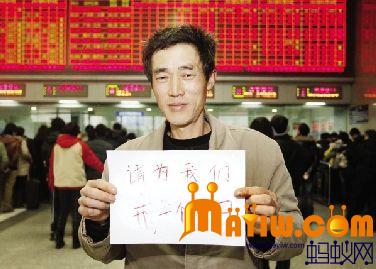 张治平手拿一个写有“请为农民工开个窗口”的牌子
